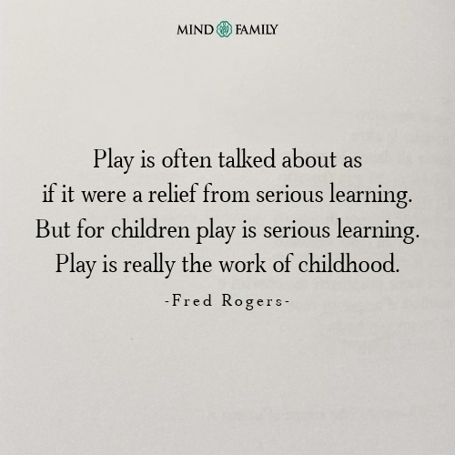 Child engrossed in building blocks while parent builds alongside